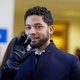 Jussie Smollett waves as he follows his attorney to the microphones after his court appearance on March 26, 2019 in Chicago, Illinois.